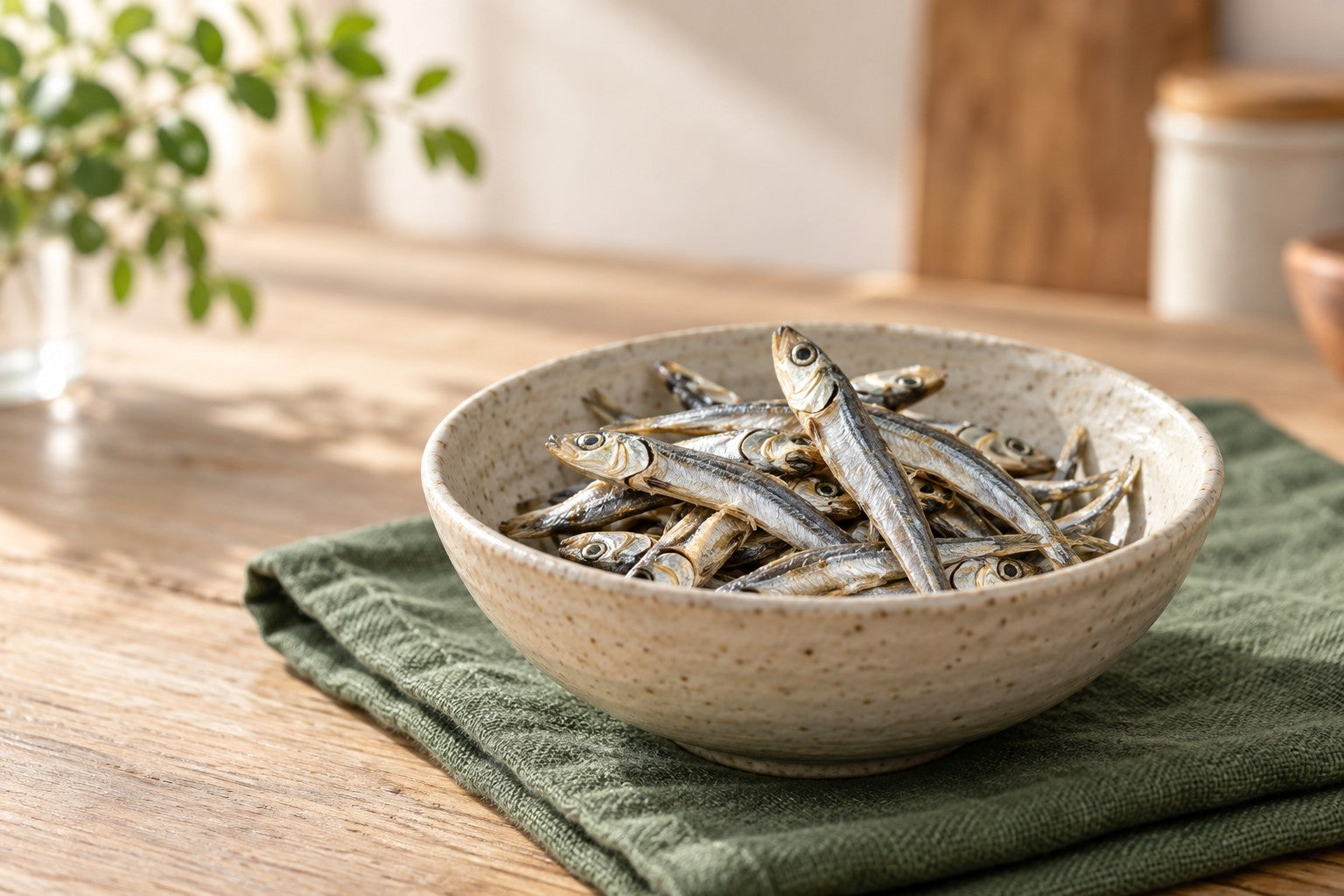 Tiny whole dried sardines arranged in a ceramic bowl