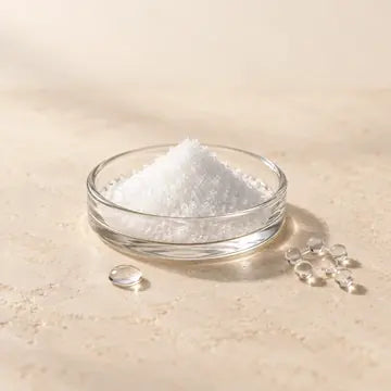 Cristaux blancs de NAD+ dans une coupelle en verre.